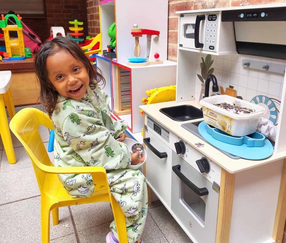 Milagros juega con una cocinita en la Casa Ronald McDonald Bogotá.
